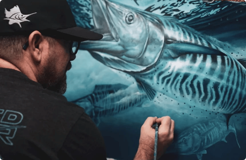 A marine artist painting a hyper-realistic wahoo mural during a From the Flybridge podcast feature.