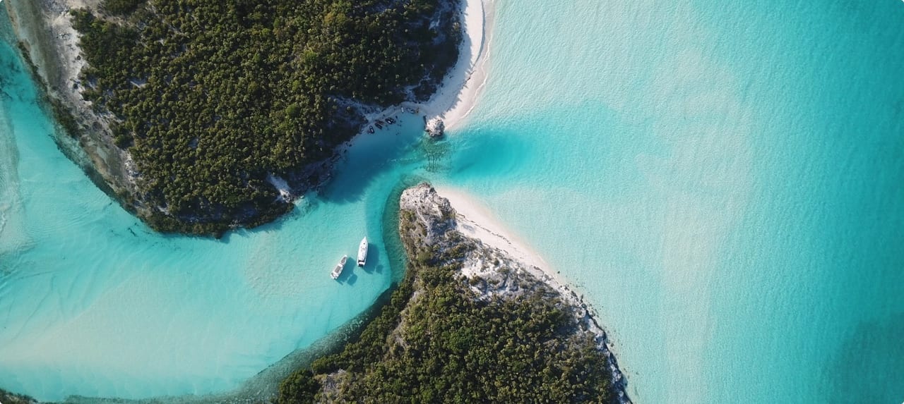 Aerial view of lush green Bahamian islands surrounded by vivid turquoise waters and white sand shoals