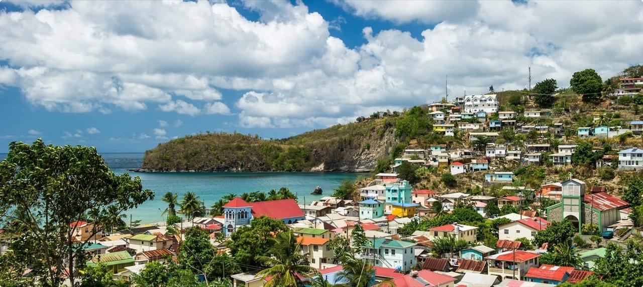 Aerial view of Marigot Bay, St. Lucia with yachts nestled in a palm-fringed harbor surrounded by verdant hillsides