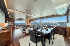 2017 Princess Yachts 88 Flybridge - Salon dining table with eight chairs and seating area beyond