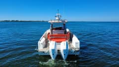 2022 40' 7" Nimbus T-11 - Stern view of a center console boat underway with twin outboard engines