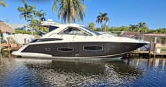 2015 Regal 53 Sport Coupe - Starboard profile view of a sport coupe motor yacht moored alongside a dock