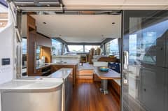 2026 Princess F58 - Salon interior viewed from aft, with galley, dinette and helm seating forward