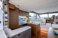 2026 Princess F58 - Interior galley with countertops and cabinetry, with salon seating beyond
