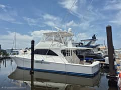 2006 57' 5" Viking 56 Convertible - Convertible sportfishing yacht with flybridge and outriggers docked at a marina slip