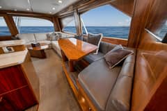 2020 Viking 68 Convertible - Salon interior with L-shaped seating, dining table and large side windows