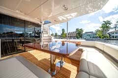 2018 66' 1" Azimut Magellano 66 - Covered cockpit with wood dining table and wraparound seating on teak deck