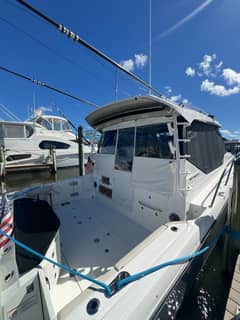 2024 41' 1" Boston Whaler 405 Conquest - Open cockpit looking forward toward enclosed helm area with canvas covers