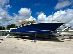 2017 42' 1" Scout 420 LXF - Blue-hulled center console boat on stands ashore, shown from the starboard side