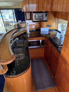 2009 63' 1" Azimut 62 Motor Yacht - Galley with curved countertop, double sink, cooktop, microwave and wood cabinetry