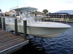 2017 28' Bluewater Sportfishing 2550 CC - Center console boat with hardtop moored alongside a wooden dock
