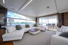 2022 Princess Y78 - Salon with L-shaped sofa, coffee table and sliding doors to aft deck