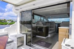 2020 46 Cruisers Cantius - Open sliding glass door between cockpit and salon with seating and galley