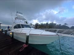 2022 Viking 44 Sport Coupe - Sportfishing yacht with tuna tower and outriggers moored alongside a dock