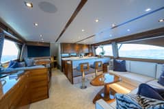 64 Convertible - Salon interior with L-shaped seating, coffee table, bar stools and galley counter
