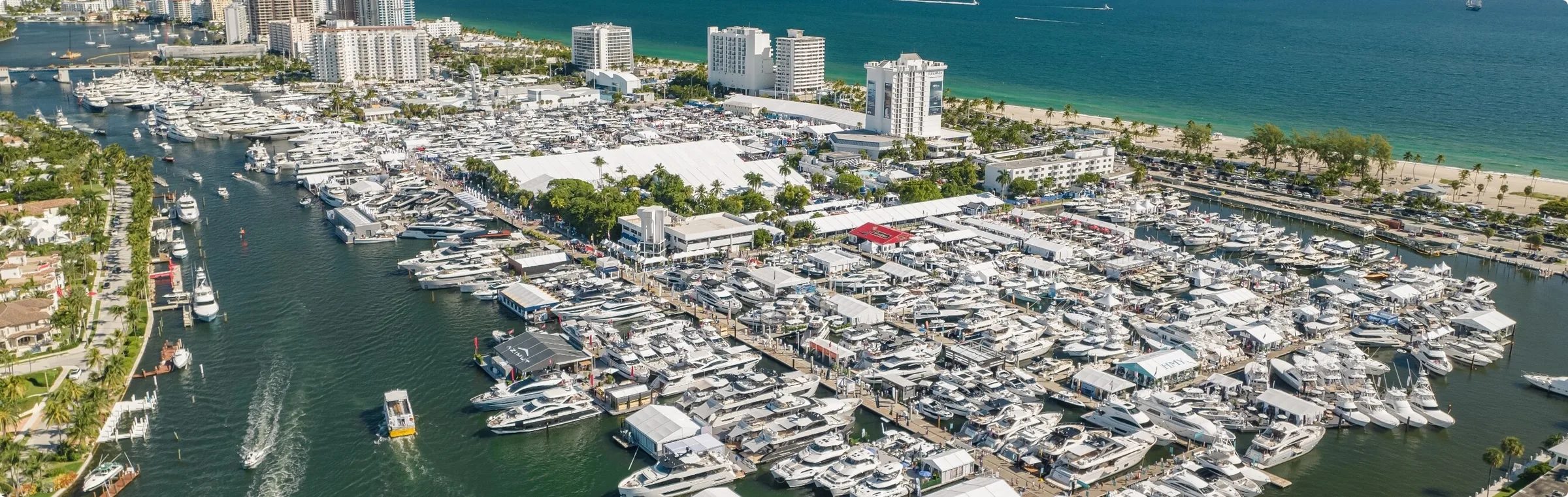 Aerial view of the Fort Lauderdale International Boat Show with yachts docked along the marina under bright sky