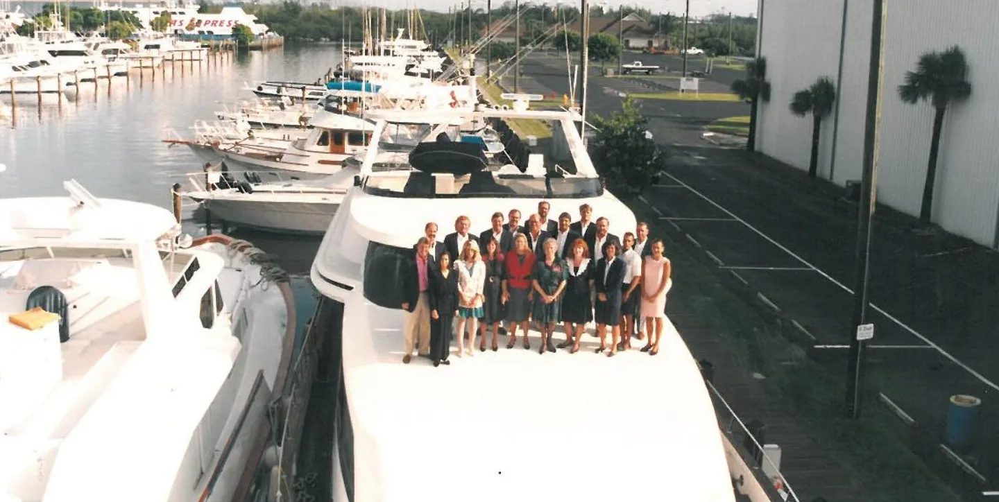 HMY Yacht Sales team gathered on the bow of a yacht at a Fort Lauderdale marina in 1994.