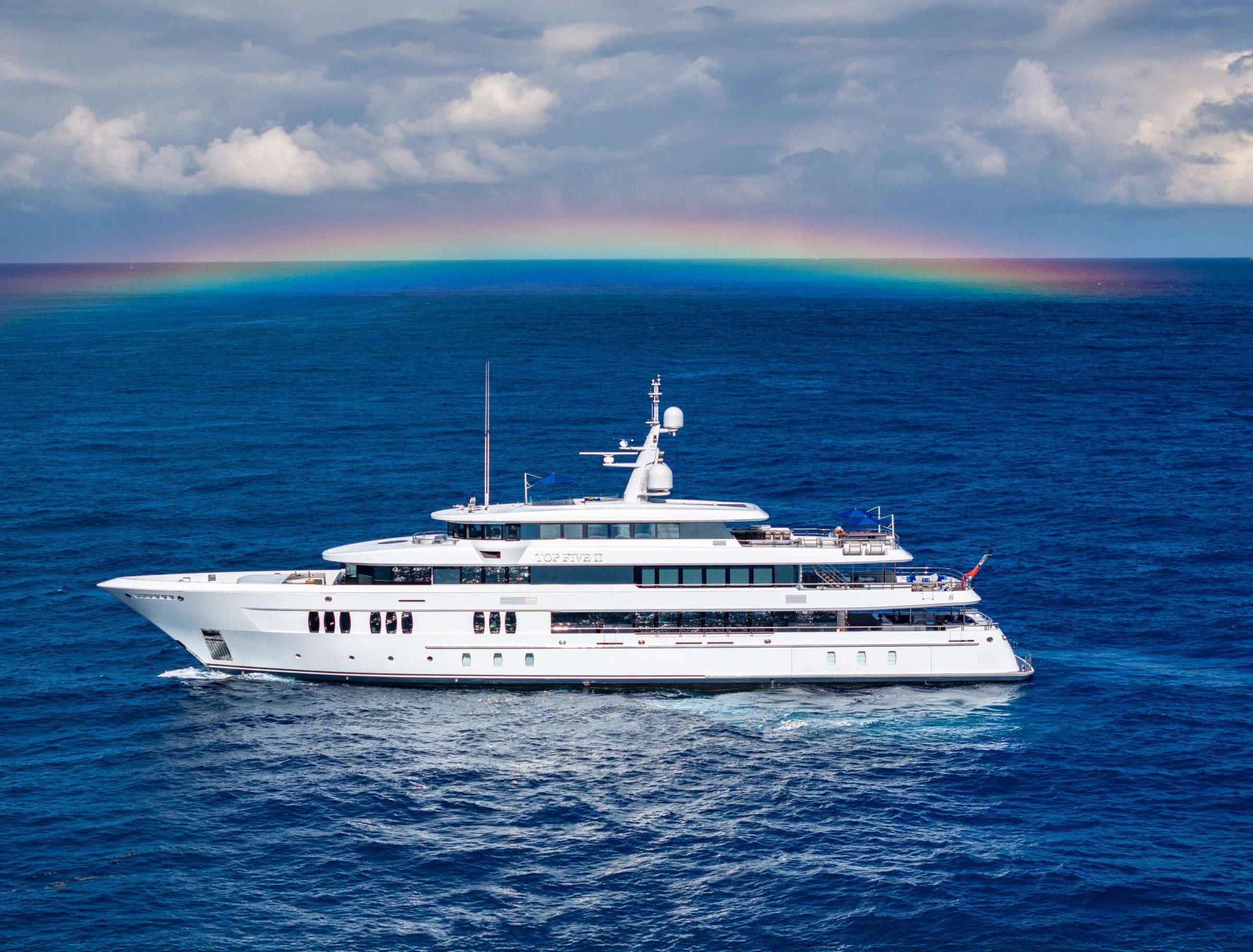 Amassing an impressive length of 200'2" (61m), the Royal Hakvoort yacht offers an array of standout amenities and reinforced hull, and immense ceiling heights throughout. Seven well-appointed guest suites and a dedicated owner’s deck provide plush accommodations for 12 onboard guests. TOP FIVE II’s voluminous interior was designed by Sinot Yacht and Architectural Design. Interior elements emulate warm and rich emotions by utilizing oak, walnut, and leather complemented with Italian marble and rich fabrics. Higher ceiling heights allow for larger windows, flooding the interior with natural light. The Royal Hakvoort living spaces were designed with entertaining in mind. Formal dining areas are featured throughout the yacht. The galley is an open, socially-oriented space, that is also properly adapted for the onboard chef. A glass elevator reaches all decks onboard, transporting guests to any of the 5 decks. The dedicated owner's deck features a private dining area and a foredeck jacuzzi for privacy and relaxation. The large king bed is surrounded by 180-degree floor-to-ceiling windows allowing sunlight to illuminate the suite. Additional guest rooms offer convertible spaces to fit any combination of families, friends, or corporate charters. Each stateroom features large windows, providing a stunning view from every angle. One stateroom is wheelchair accessible. TOP FIVE II is also equipped with Starlink Maritime.