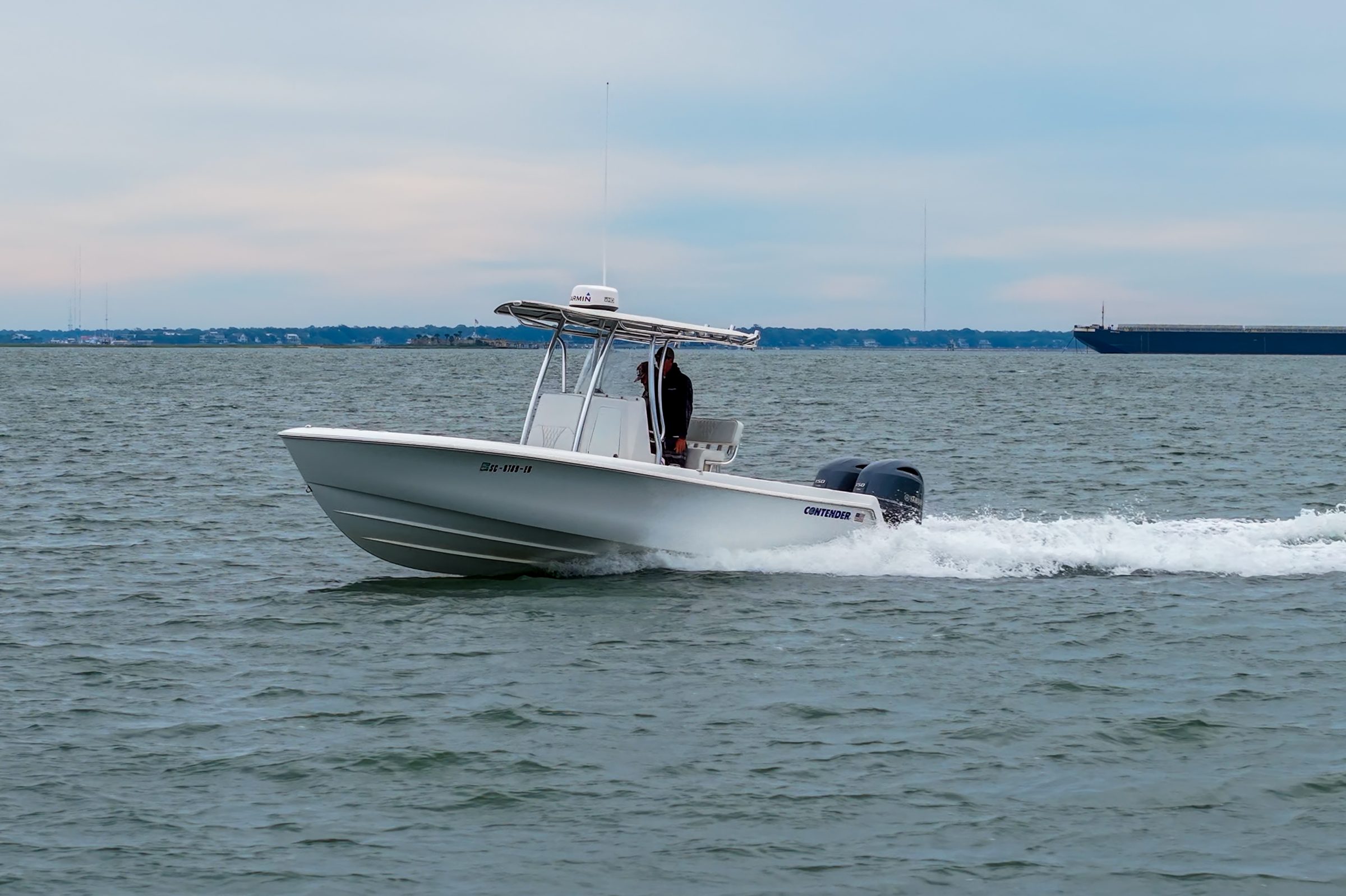 2023 24' 6" Contender 24S - White center console boat with T-top underway on open water
