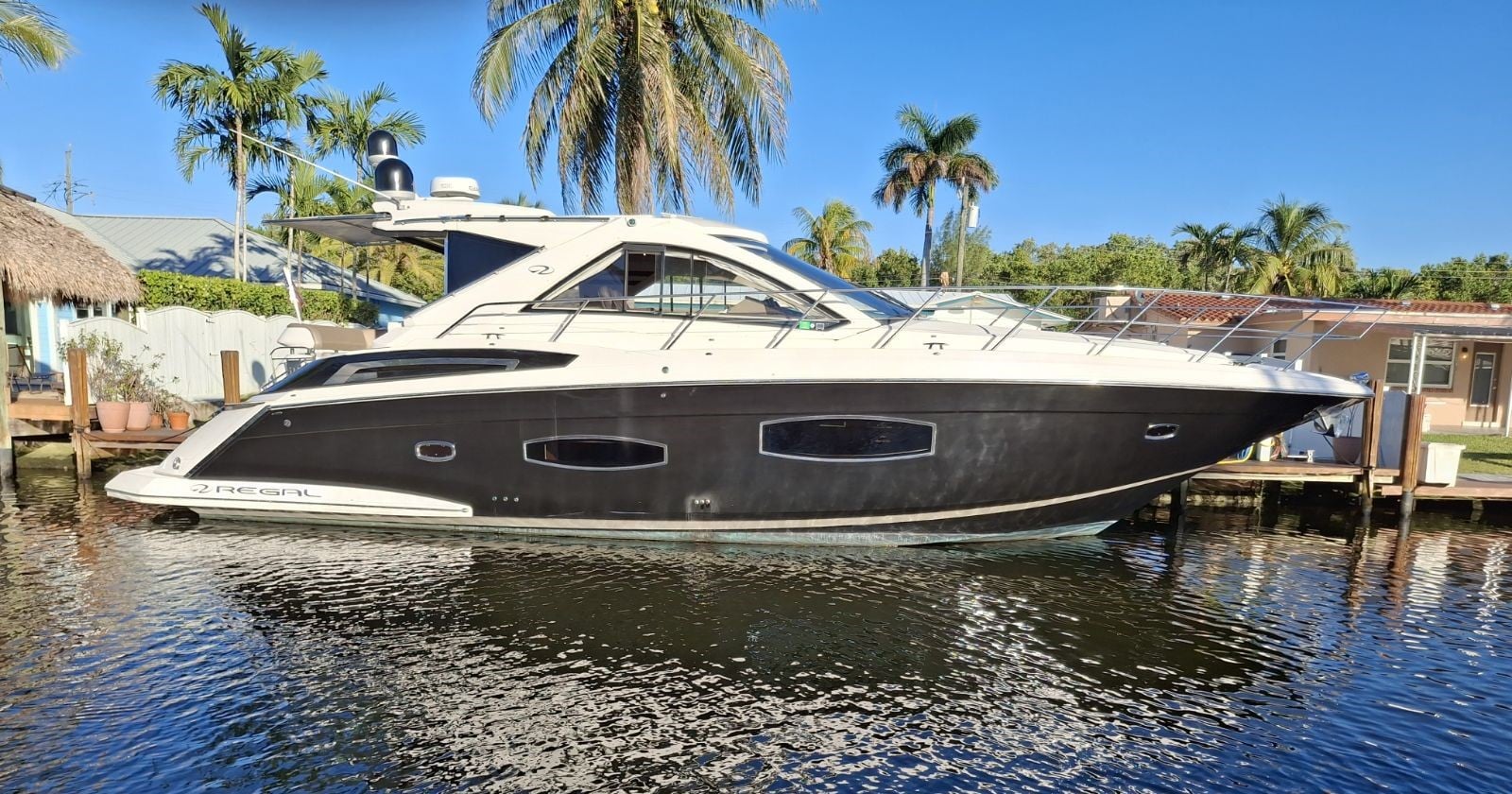2015 Regal 53 Sport Coupe - Starboard profile view of a sport coupe motor yacht moored alongside a dock