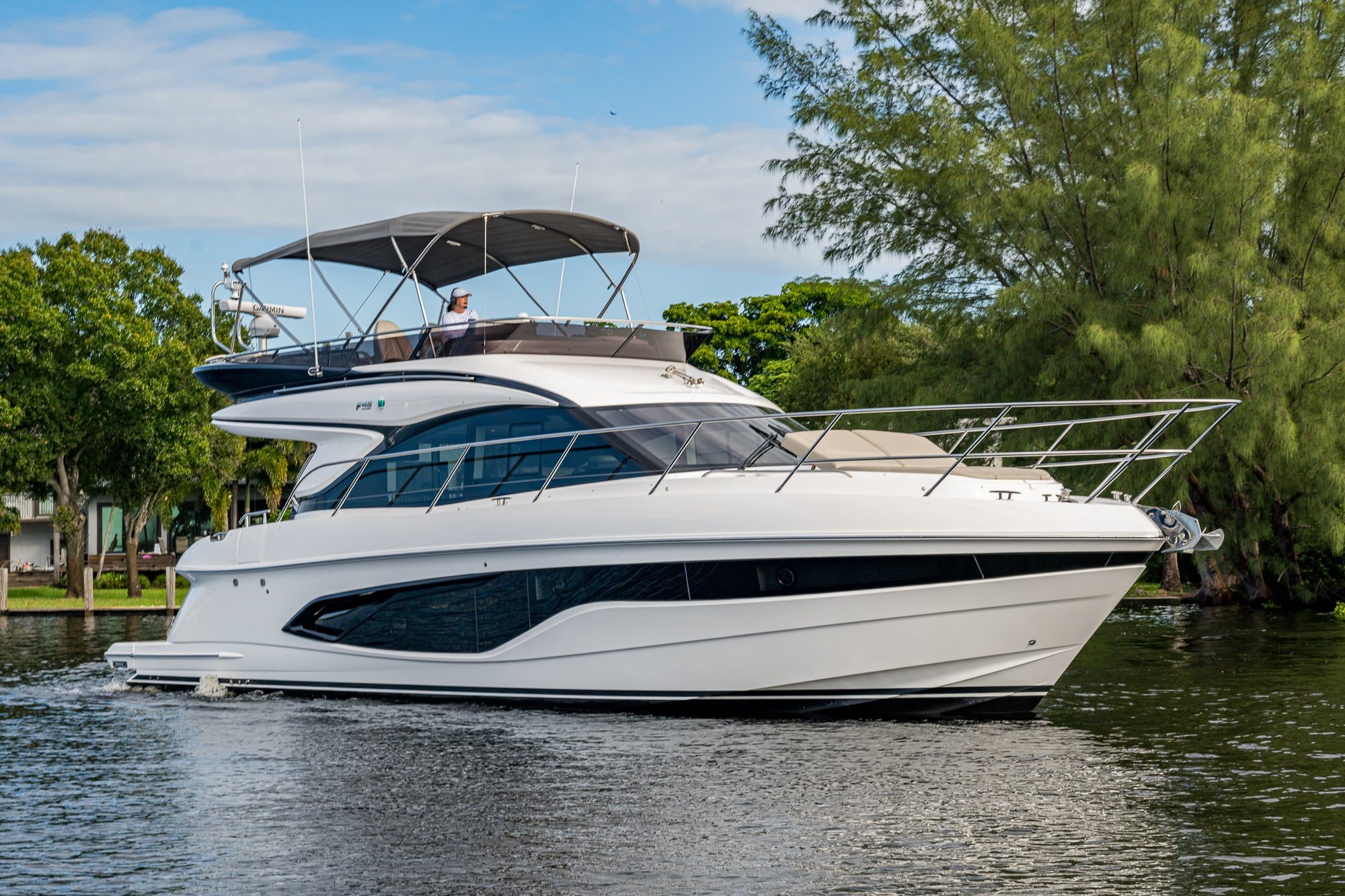 2025 47' 1" Princess F45 - White flybridge motor yacht underway on water, starboard bow view, with person at upper helm