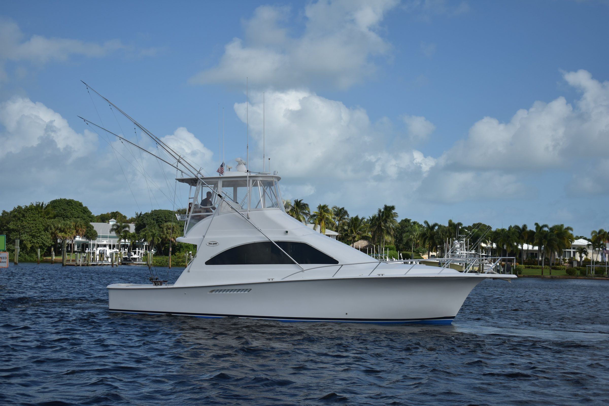 2006 Ocean Yachts 42 Super Sport - Starboard profile of a white sportfishing convertible underway with outriggers raised