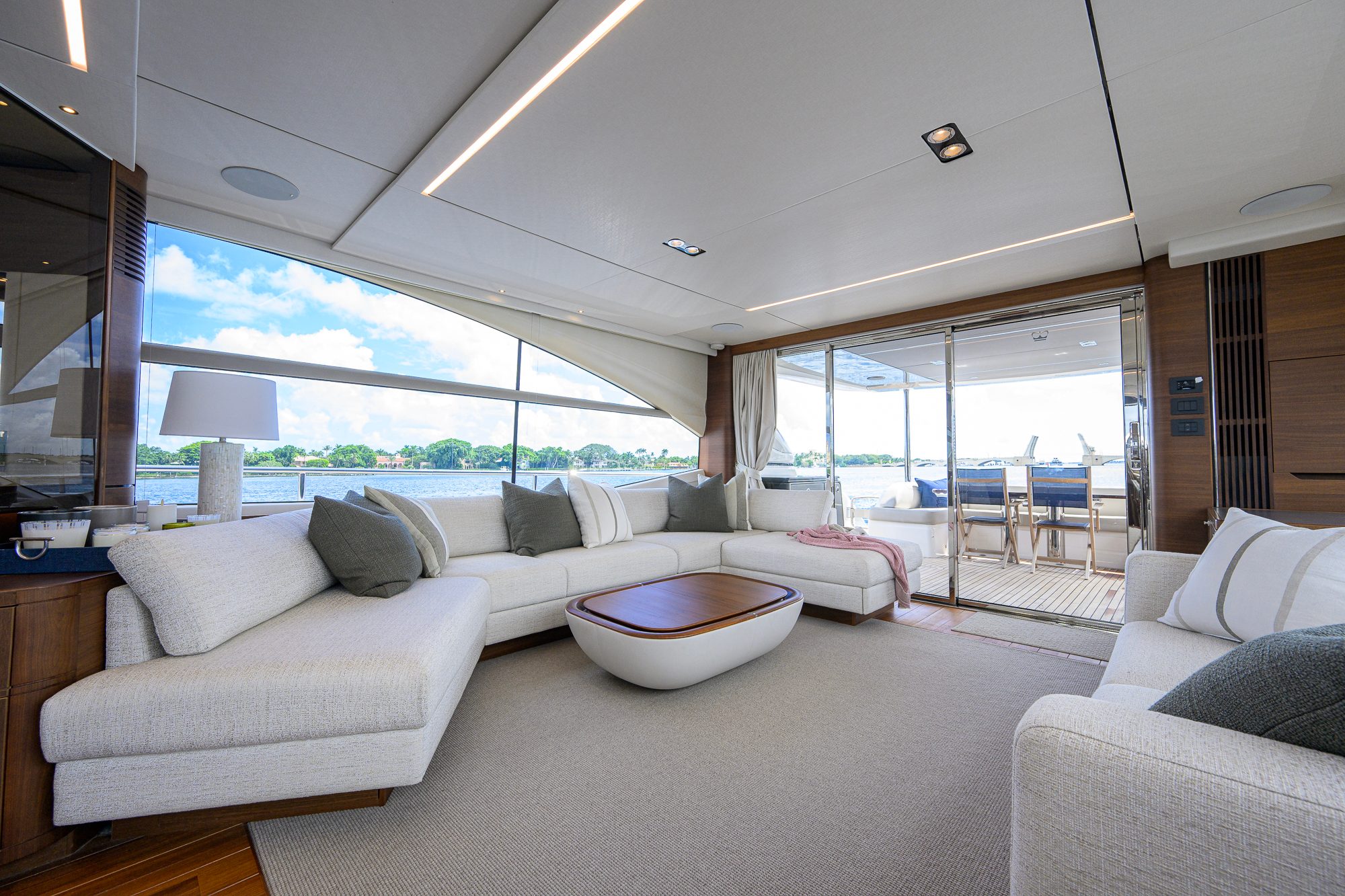 2022 Princess Y78 - Salon with L-shaped sofa, coffee table and sliding doors to aft deck