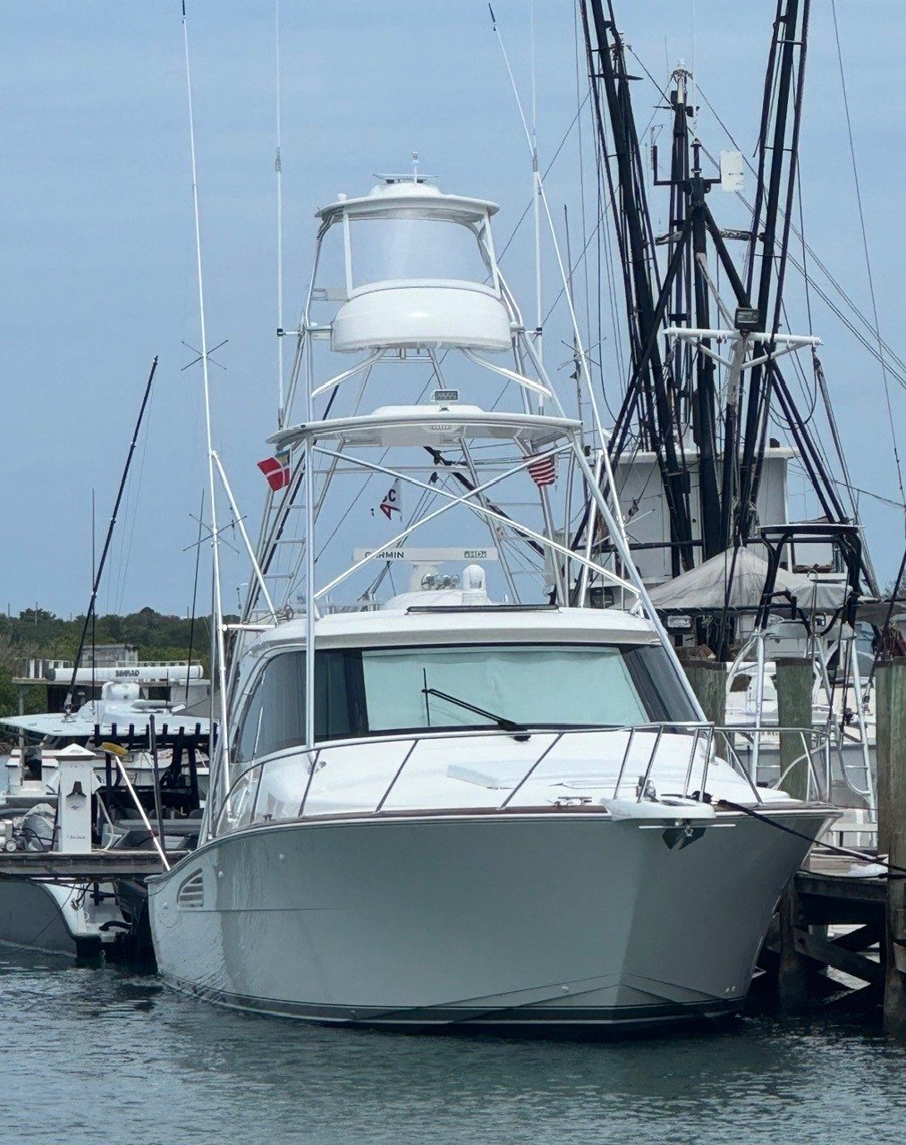 2022 Viking 44 Sport Coupe - Bow view of a white sportfishing yacht with tuna tower, moored at a dock