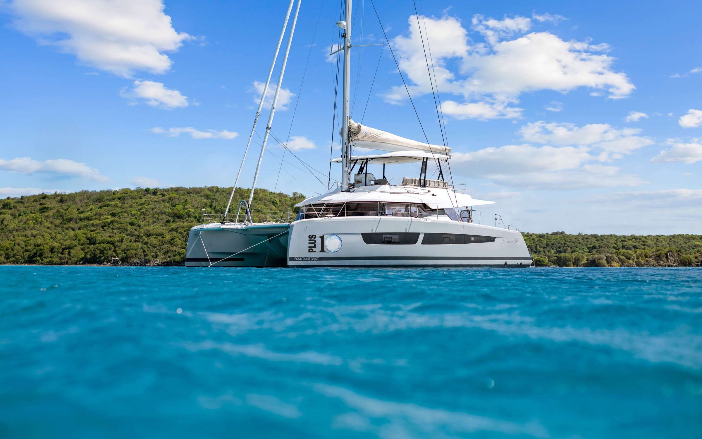 PLUS 10 is a Fountaine Pajot Samana 59 sailing catamaran designed for next-level space, style, and Virgin Islands adventure. A true highlight is the hard-covered flybridge&mdash;the largest in its class&mdash;with plush daybeds and a full lounge for panoramic views from sunrise to stargazing. The bow&rsquo;s sunken seating and trampoline add another favorite hangout, while the aft lounge&rsquo;s teak table seats 8 for effortless alfresco meals. Inside, a spa-like interior features a drop-down TV and sleek bar for relaxed evenings. Sleeps up to 8 in 5 cabins, each with a private ensuite and individual A/C controls&mdash;ideal for extra space and privacy. Water toys are included for endless fun on the water, plus a strong tender for exploring. Big spaces. Calm luxury. Pure wow&mdash;PLUS 10 earns the name.