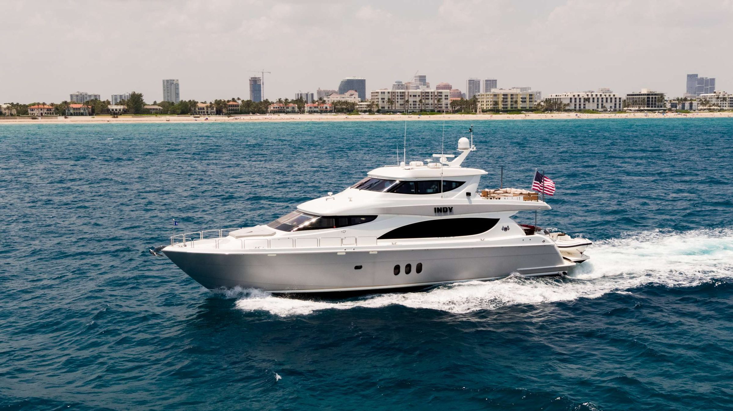 Welcome aboard INDY, where elegant styling, luxurious accommodations, and impressive performance await you. Fresh from a 2023 refit by acclaimed interior designer Patrick Knowles, INDY seamlessly blends luxury and comfort, making it the perfect charter choice. With a cruising speed of 19 knots and a top speed of 25 knots, INDY promises swift and stylish journeys. Its 21.3-foot beam, comparable to that of most 90-foot yachts, offering expansive space, while the solid fiberglass hull ensures exceptional strength and durability. INDY accommodates eight guests in four spacious cabins, along with a crew of four.

The expansive main salon on INDY features custom furnishings and a formal dining area with a custom-designed marble table and luxurious chairs. Start your day here with a tailor-made breakfast spread or unwind in the evening with a drink from the full bar while lounging on the sofa. INDY&rsquo;s galley and seating area are equipped with all the necessities to create delicious meals while underway and can be closed off for extra privacy. Entertainment possibilities abound with the aft deck&rsquo;s U-shaped sofa for alfresco dining, the aft flybridge&rsquo;s grill, lounging chairs, and the perfect settee for enjoying sunset beverages and canopies. The enclosed flybridge is ideal for watching the horizon in complete comfort, featuring two sofas, a 2nd bar, and a pop-up TV.

INDY&rsquo;s full-beam master suite includes a king-size bed and lounge area, with an ensuite equipped with His and Hers entryways and an oversized shower. The VIP stateroom and guest cabins are equally luxurious, ensuring all guests enjoy complete comfort and privacy. Additional features include Smart TVs, dedicated ensuites, and lavishly appointed guest robes in all cabins.

An extended hydraulic swim platform, 76 inch tall ceilings and Naiad stabilizers complete INDY's impressive charter profile, with a professional crew ready to cater to your needs at a moment's notice