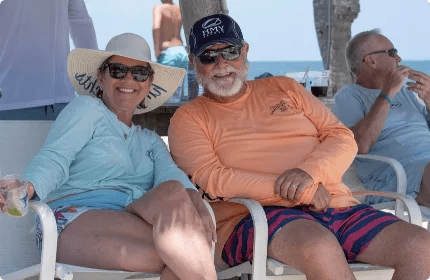 HMY owners Faith and Steve Moynihan in branded fishing shirts relaxing beachside during a tournament weekend.