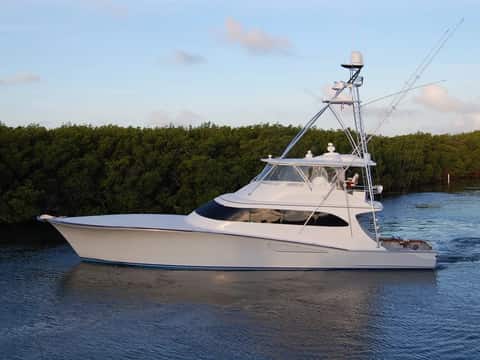 A Weaver 75 custom sportfish underway on calm water at sunset.
