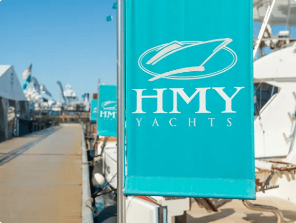 Teal HMY Yachts banners hanging at an HMY display during a major yacht show.