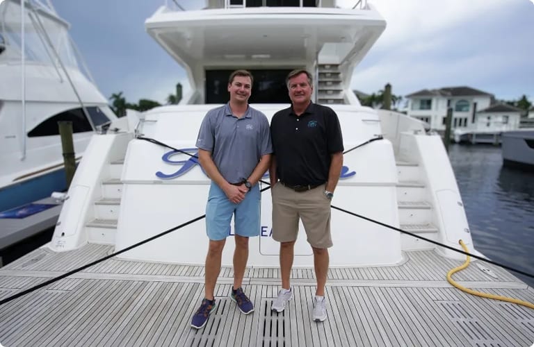 Forrest and Jack Robertson on the swim platform of a yacht at an HMY brokerage location.