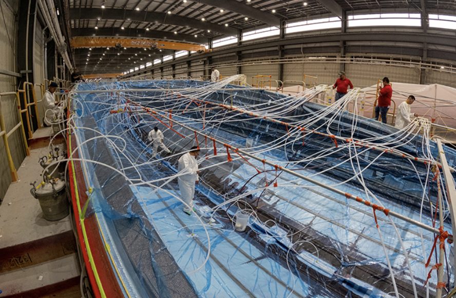 Multiple lines cross over the hull of the Viking 90 sportfish with resign moving throughout to continue the resign infusion process. 