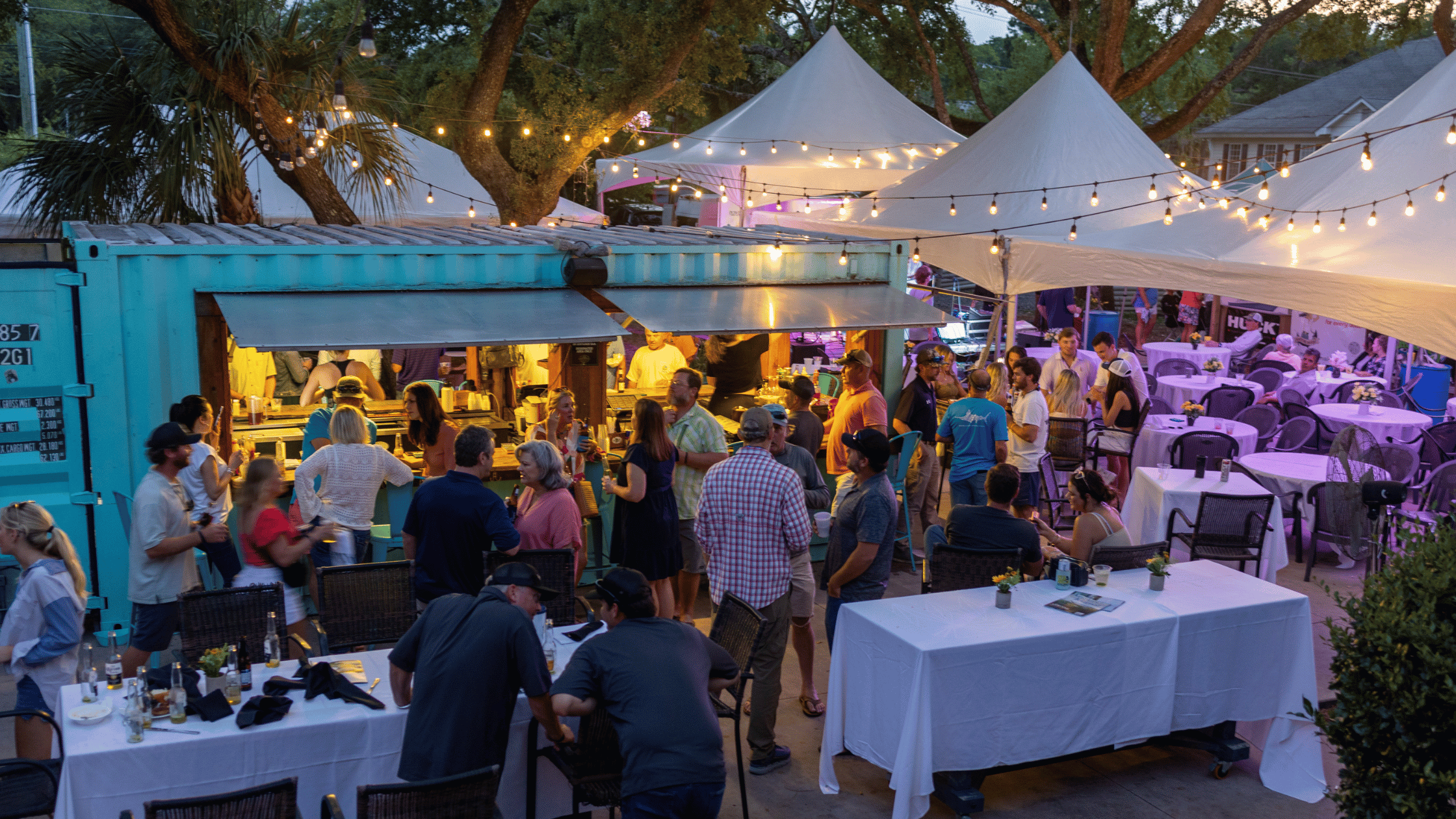 Bright lights and event attendees mingling at the Captain's Meeting for the Lowcountry Cup. 