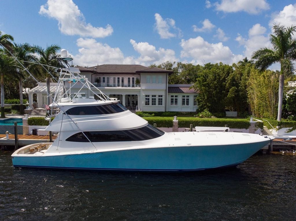 Light blue Viking Yachts 82 on a canal behind a house